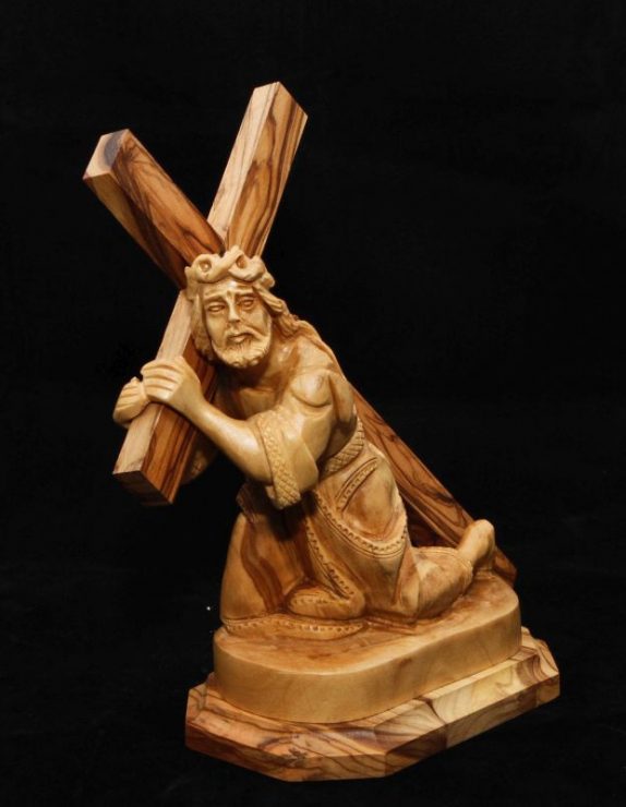Jesus holding the cross kneeling